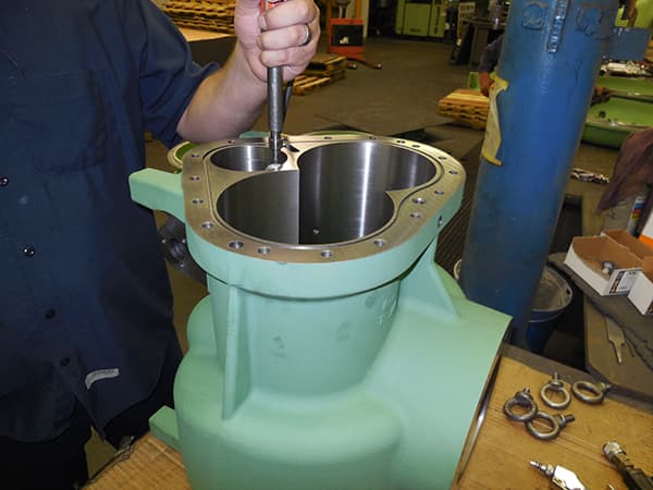 Machinist assembling a green pump housing
